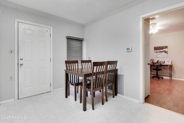 dining area featuring baseboards, visible vents, and light floors