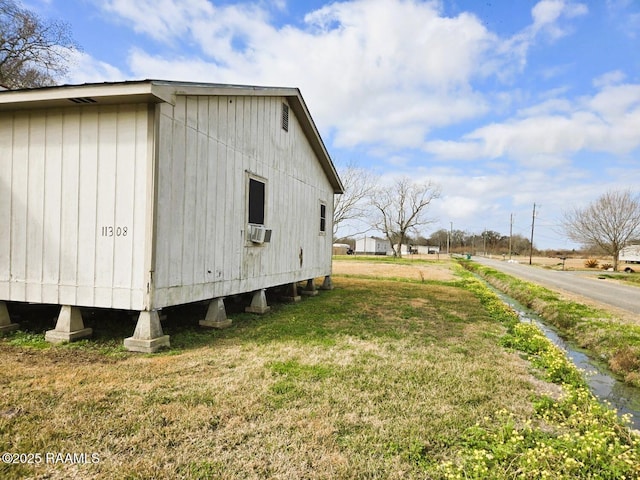 view of side of property featuring cooling unit and a lawn