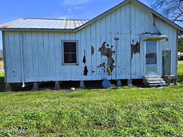 view of side of home with a yard