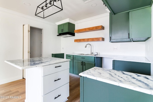 kitchen featuring sink, crown molding, light hardwood / wood-style flooring, green cabinets, and light stone countertops