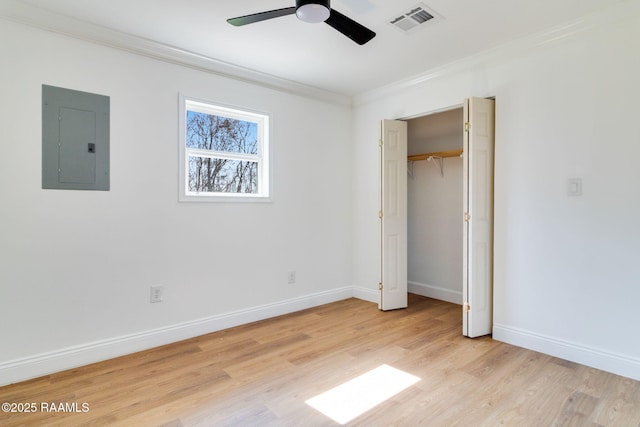 unfurnished bedroom with crown molding, electric panel, light hardwood / wood-style floors, and ceiling fan