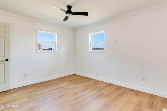 empty room featuring crown molding, light hardwood / wood-style flooring, and a wealth of natural light