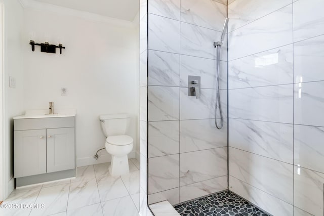 bathroom with vanity, crown molding, toilet, and tiled shower