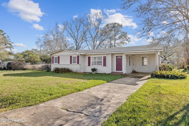 ranch-style home featuring concrete driveway and a front yard