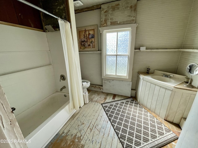 full bathroom featuring a sink, toilet, hardwood / wood-style floors, and shower / tub combo