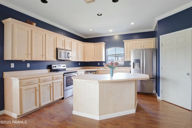 kitchen featuring light brown cabinetry, wood-type flooring, a center island, ornamental molding, and stainless steel appliances