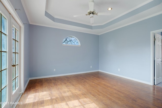 spare room featuring a raised ceiling, ornamental molding, ceiling fan, and light hardwood / wood-style flooring