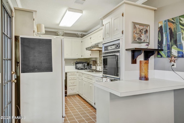 kitchen with light tile patterned flooring, stainless steel appliances, white cabinetry, and kitchen peninsula