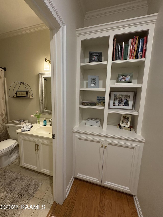 bathroom with vanity, hardwood / wood-style floors, crown molding, and toilet