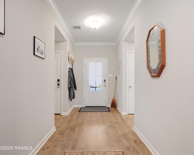 doorway to outside featuring crown molding and light hardwood / wood-style floors