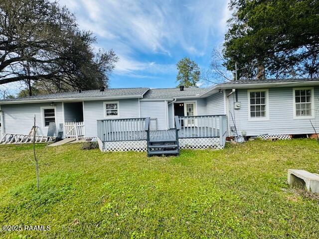 back of property featuring a yard and a wooden deck