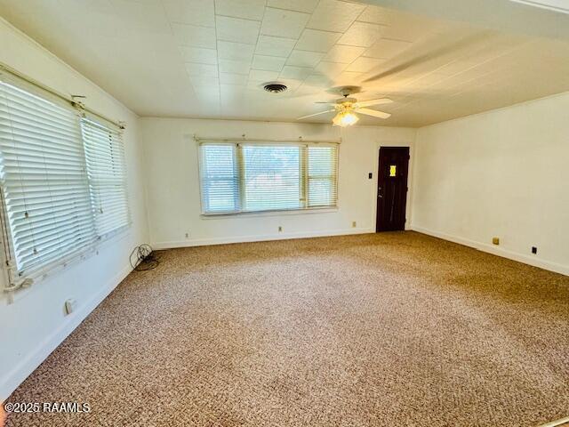 unfurnished room featuring a ceiling fan, carpet, visible vents, and baseboards