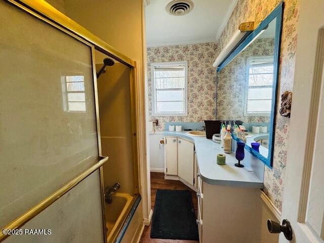 bathroom with enclosed tub / shower combo, visible vents, plenty of natural light, and wallpapered walls