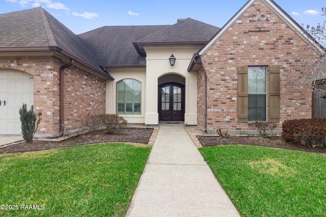 property entrance featuring a yard, french doors, and a garage