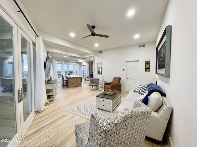 living room with light hardwood / wood-style floors, french doors, and ceiling fan