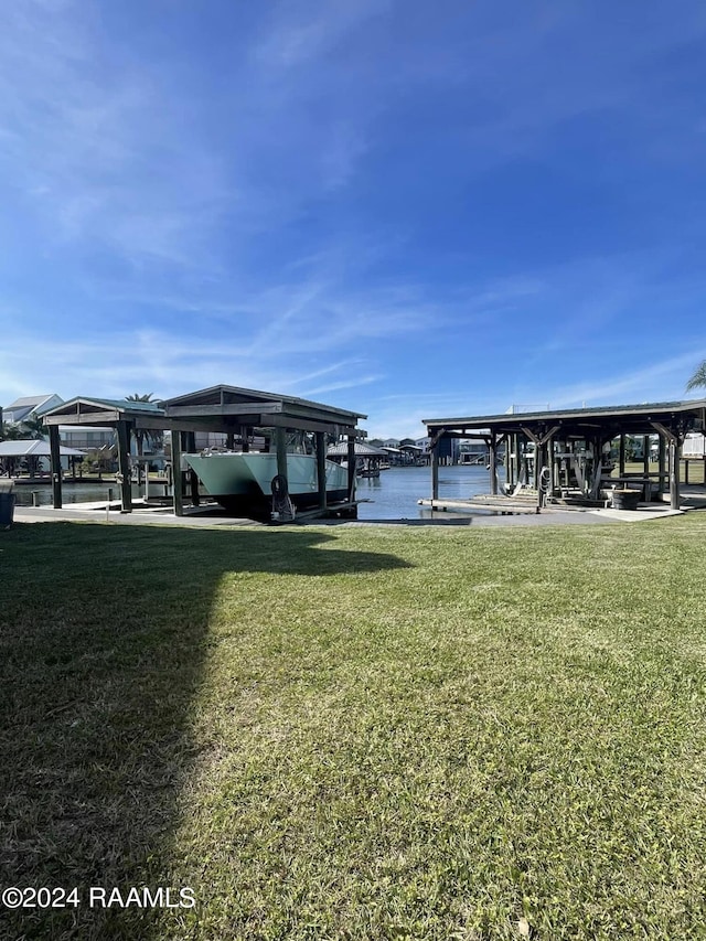 view of dock featuring a lawn and a water view