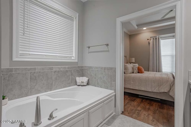 ensuite bathroom featuring a garden tub, wood finished floors, and connected bathroom