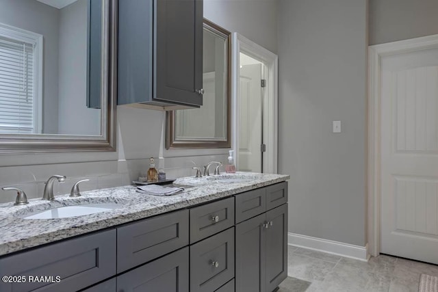 full bath with a sink, baseboards, and double vanity