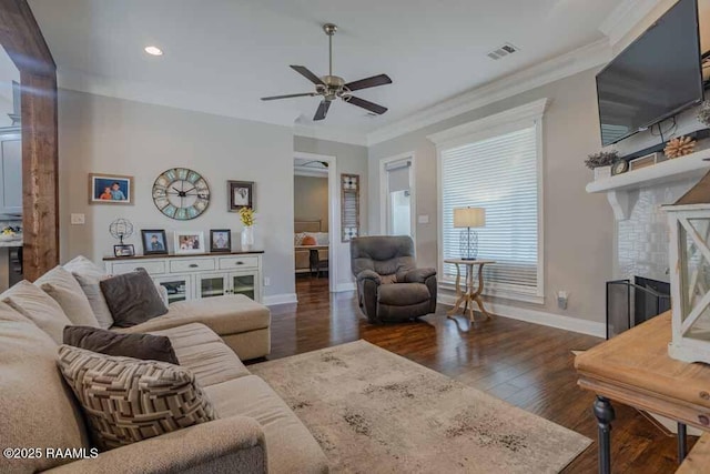 living area featuring visible vents, crown molding, baseboards, a fireplace, and wood finished floors