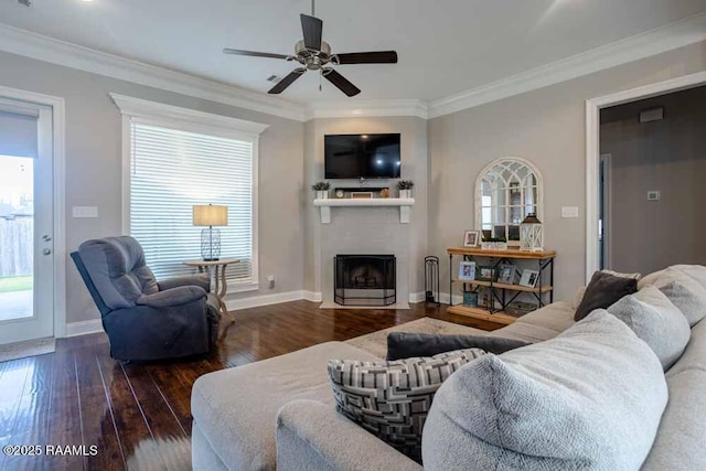 living area featuring a fireplace with flush hearth, ornamental molding, baseboards, and hardwood / wood-style flooring