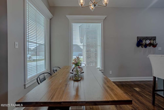 dining room featuring baseboards, a notable chandelier, a healthy amount of sunlight, and dark wood-style flooring