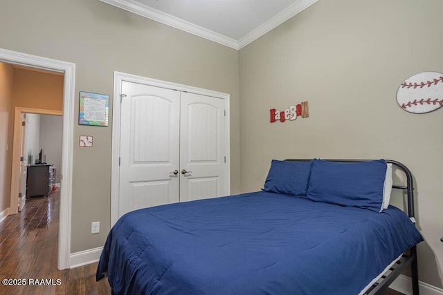 bedroom featuring wood finished floors, baseboards, a closet, and ornamental molding