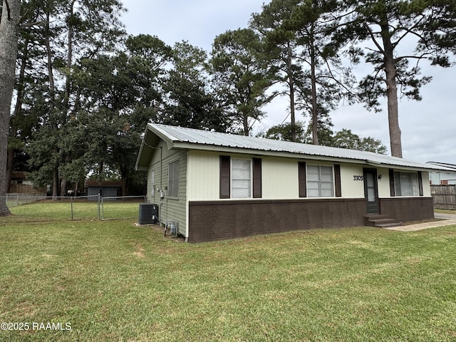 view of front of home with central AC and a front yard