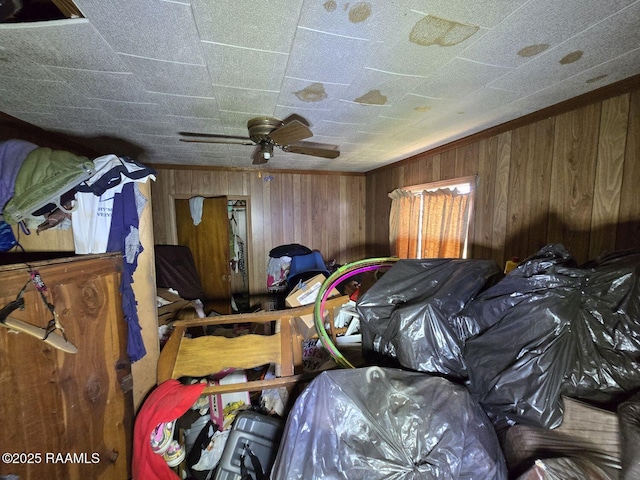 bedroom featuring ceiling fan and wooden walls