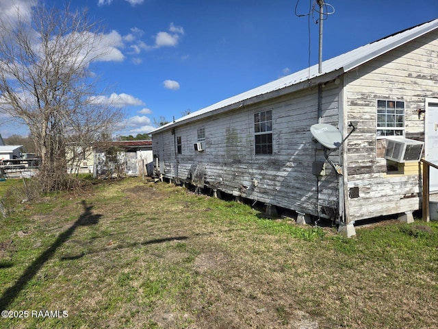 view of home's exterior with cooling unit and a lawn