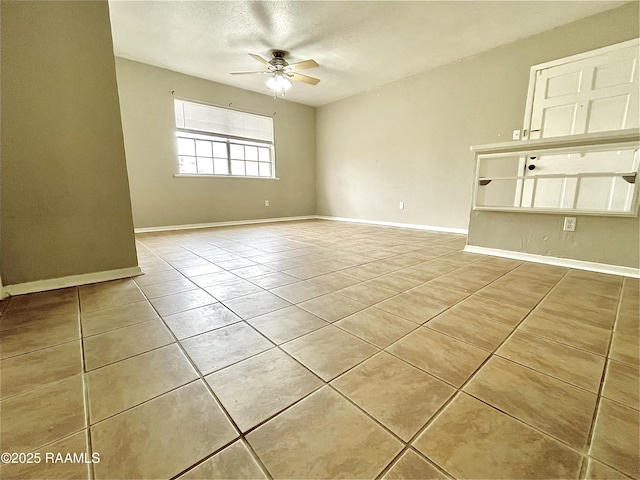 tiled spare room featuring a textured ceiling and ceiling fan