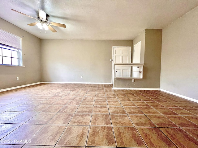 tiled empty room featuring ceiling fan