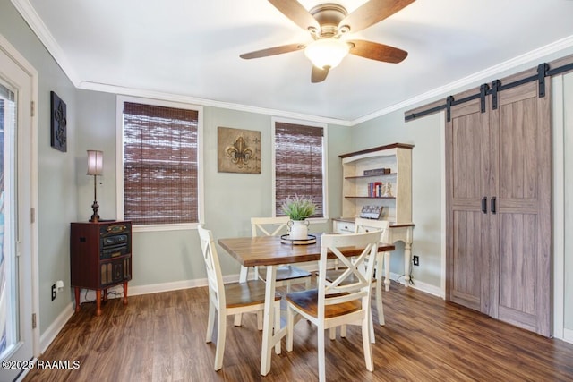 dining room with ornamental molding, dark hardwood / wood-style floors, ceiling fan, and a barn door