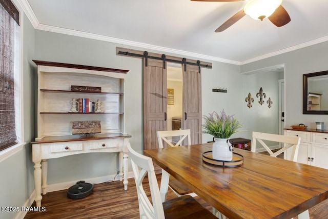 dining space with hardwood / wood-style flooring, ornamental molding, a barn door, and ceiling fan