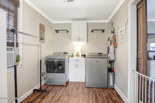 laundry room featuring dark wood-type flooring, cabinets, ornamental molding, and washing machine and clothes dryer