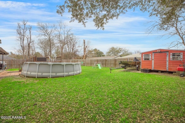 view of yard featuring a fenced in pool and a shed