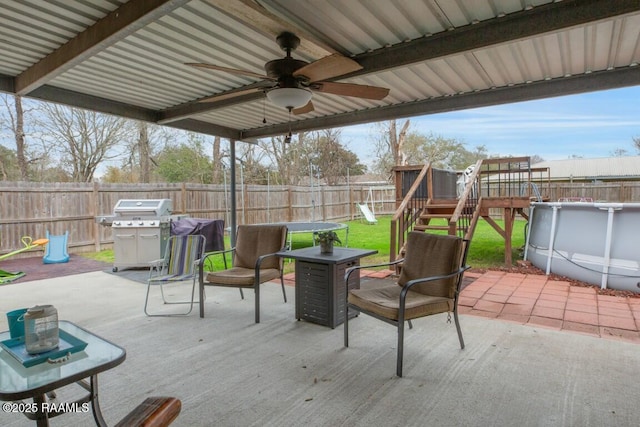 view of patio / terrace featuring area for grilling, a fenced in pool, and a playground