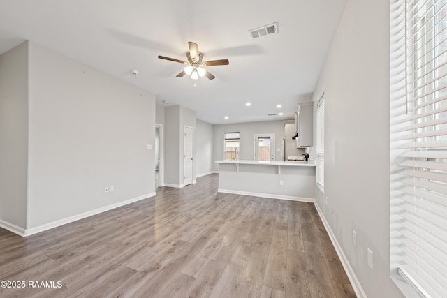 unfurnished living room with ceiling fan and light wood-type flooring