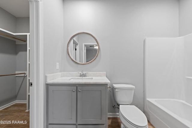 full bathroom featuring hardwood / wood-style floors, shower / bath combination, vanity, and toilet