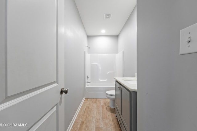 full bathroom featuring hardwood / wood-style flooring, vanity, bathing tub / shower combination, and toilet