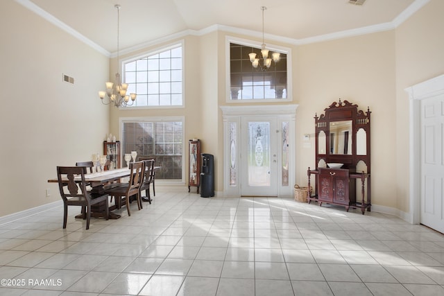 entrance foyer with light tile patterned flooring, high vaulted ceiling, ornamental molding, and a chandelier