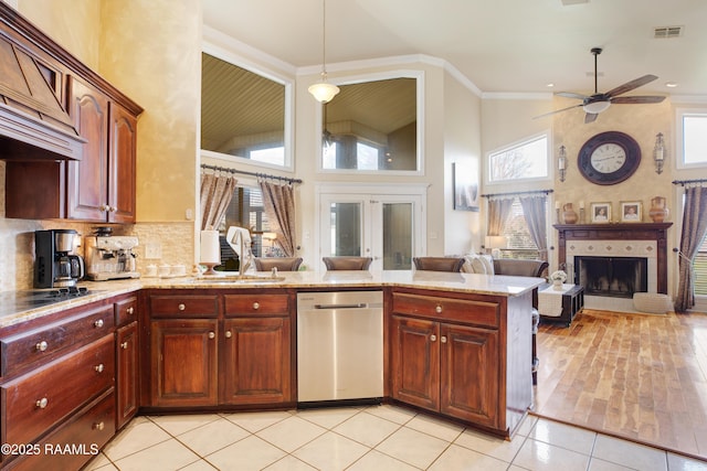 kitchen with a tile fireplace, sink, custom exhaust hood, stainless steel dishwasher, and light tile patterned floors