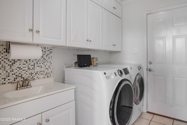 laundry room with cabinets, washing machine and dryer, sink, and light tile patterned floors