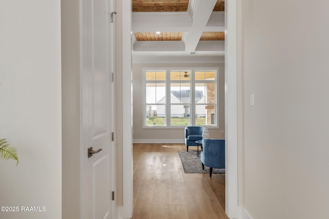 hallway with beamed ceiling, ornamental molding, coffered ceiling, and light wood-type flooring