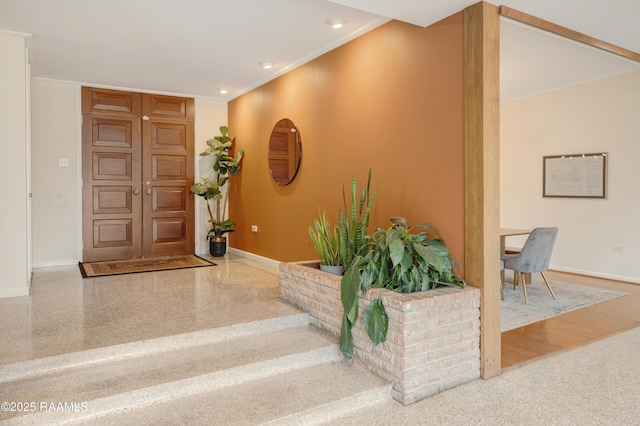 foyer entrance featuring recessed lighting, baseboards, speckled floor, and ornamental molding