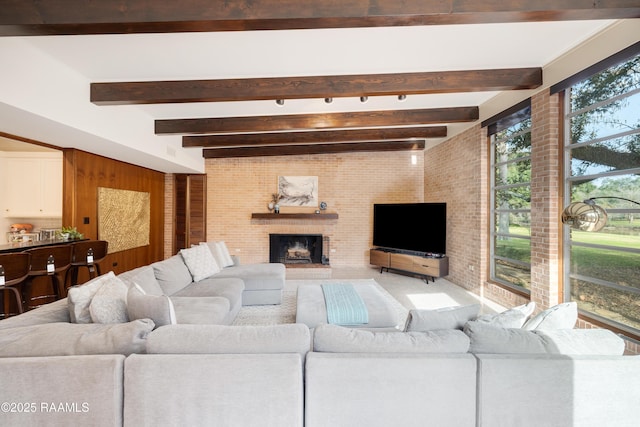 living room with beamed ceiling and a brick fireplace