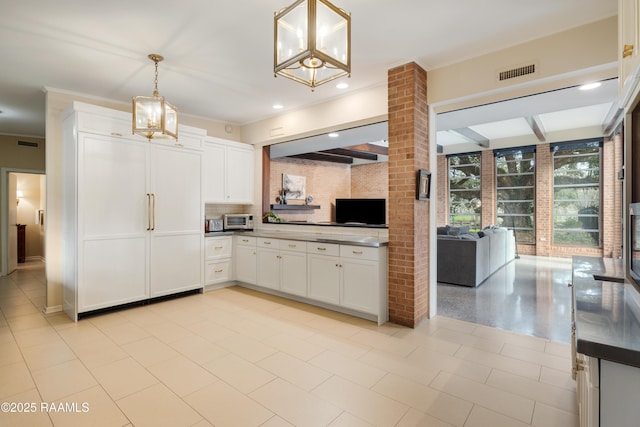 kitchen with visible vents, white cabinetry, open floor plan, hanging light fixtures, and dark countertops