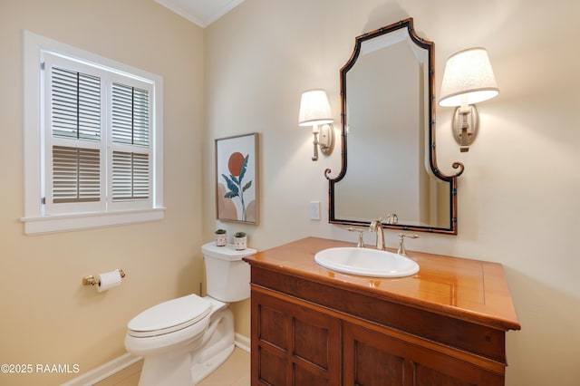 half bathroom with baseboards, vanity, and toilet