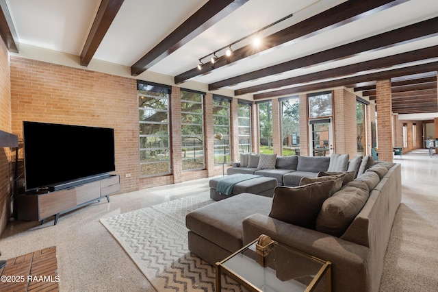 living room featuring brick wall and beamed ceiling