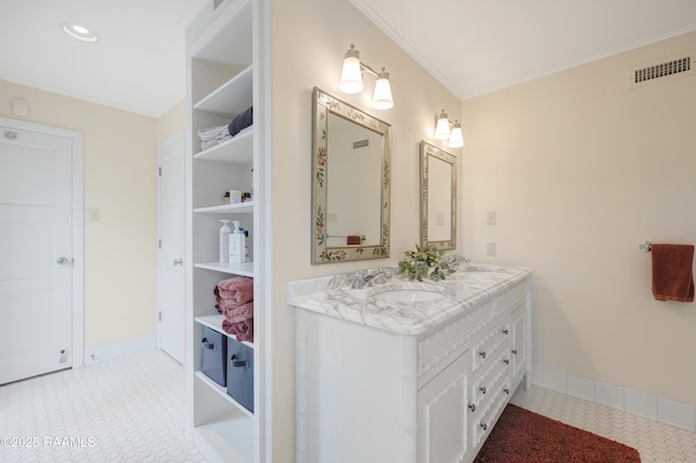 full bath with a sink, visible vents, baseboards, double vanity, and crown molding