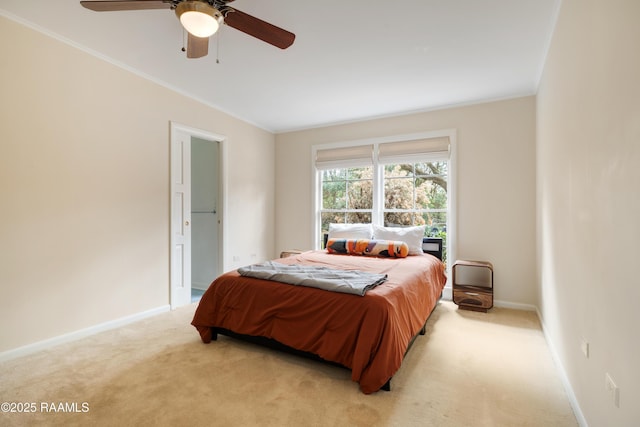 bedroom with light carpet, ceiling fan, baseboards, and crown molding